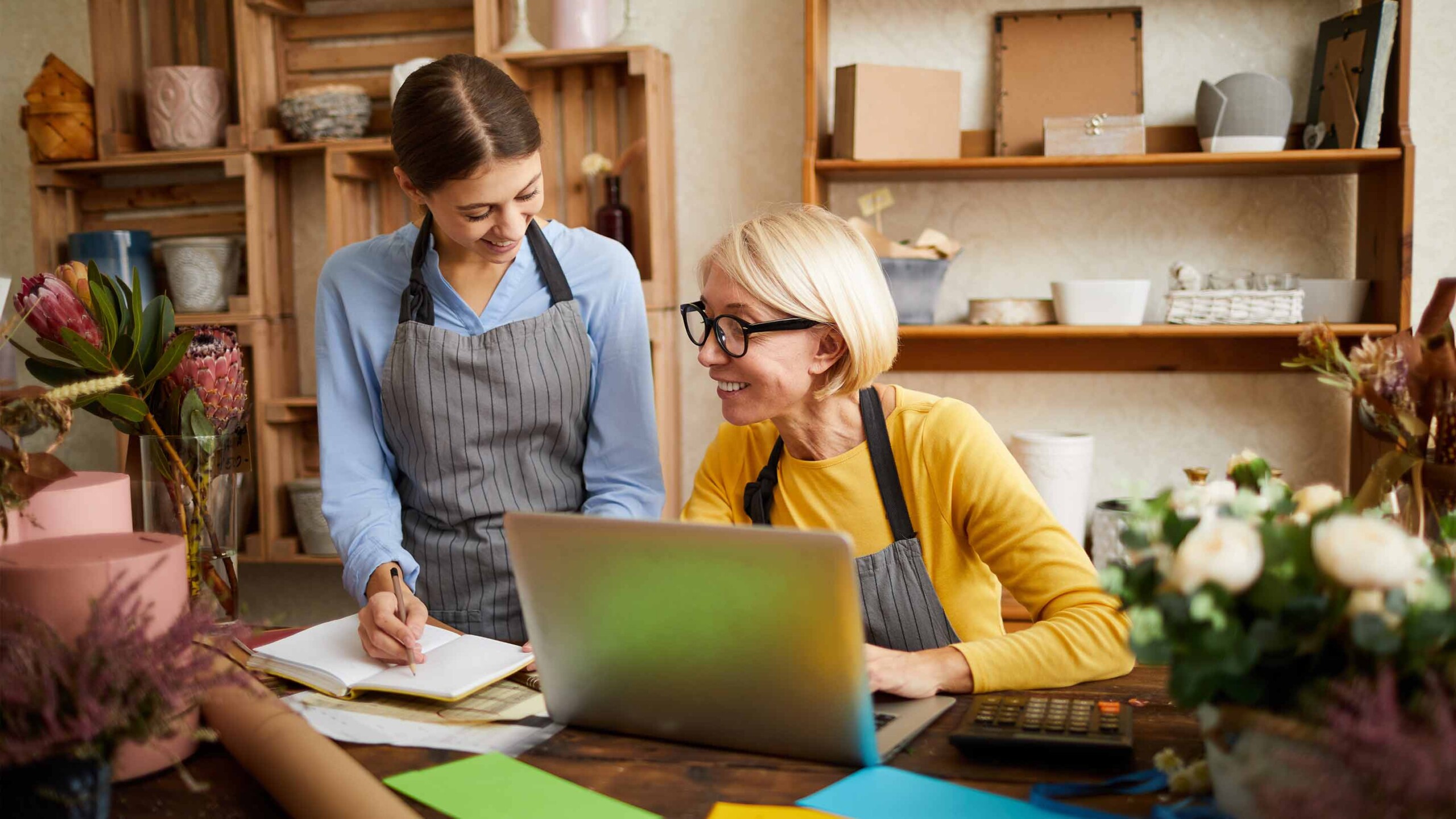 business owner with employee smiling and reviewing paperwork