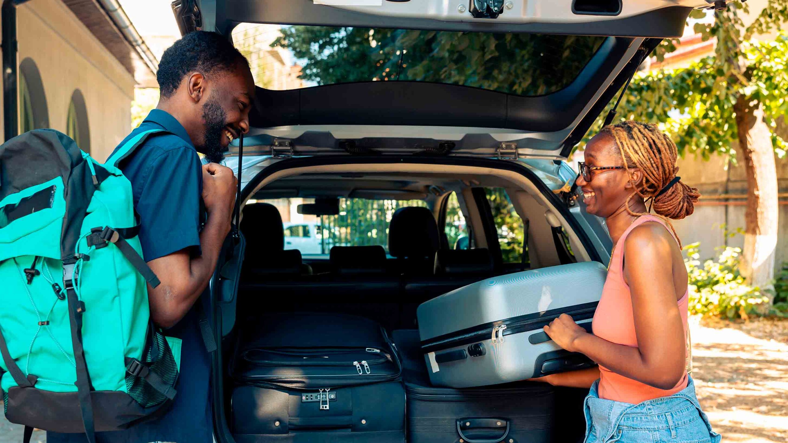 people packing car with suitcases